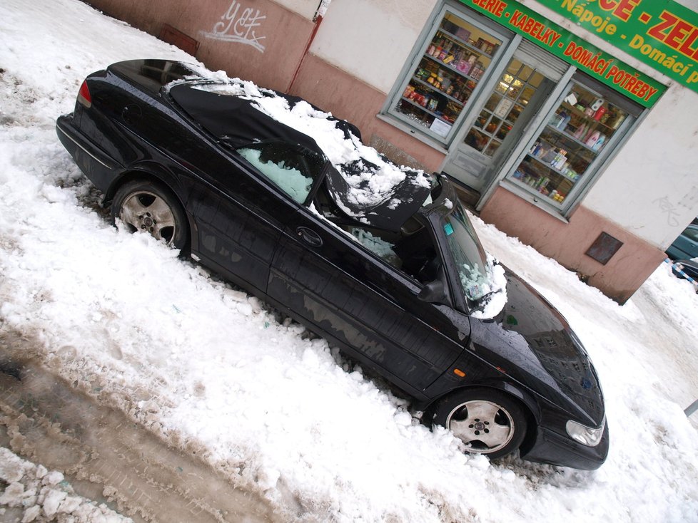Hromady sněhu, padající ze střech, poškodila na několika místech parkující auta.