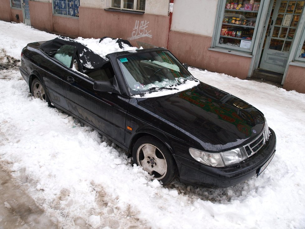 Hromady sněhu, padající ze střech, poškodila na několika místech parkující auta.