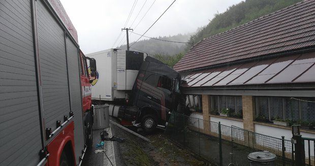 Kamion zůstal zaklíněný v domě po bouračce s autem. Řidič osobáku zemřel