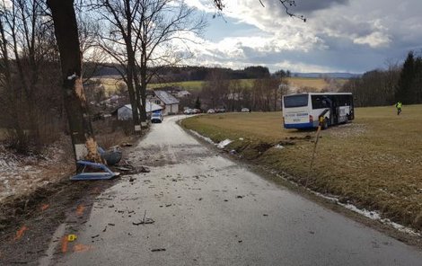 Poničený autobus po nárazu skončil v poli.