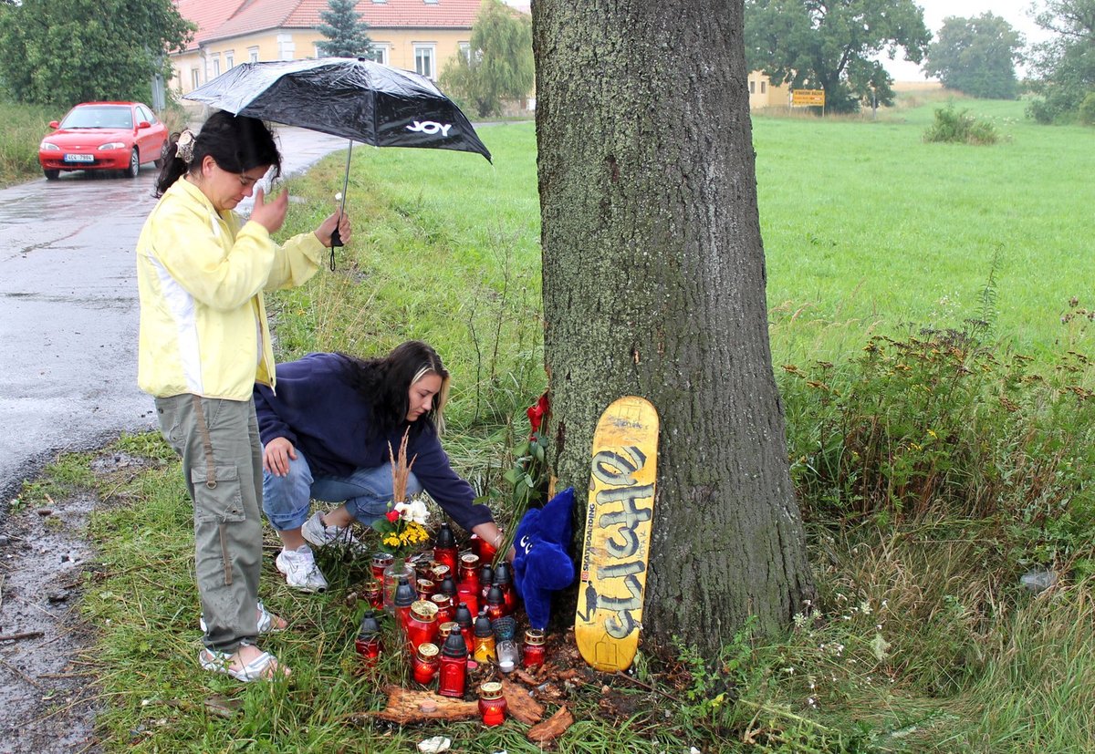 Příbuzní a kamarádi zapalují na místě neštěstí svíčky. Přišla i zlomená sestra (v modré mikině) Jirky, který na místě umřel.