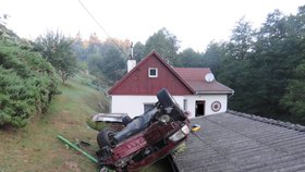 Vůz skončil střechou na střeše domu.