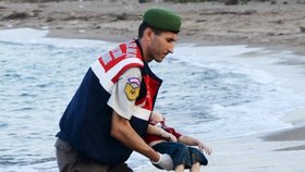 Turecký četník odnáší tělíčko utopeného tříletého syrského chlapce Ajlana.