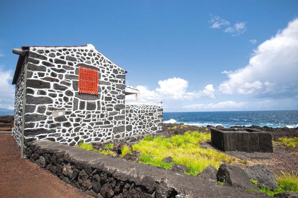 Při jízde kolem ostrova Pico uvidíte spoustu těchto kamenných domů s typickou bílou barvou mezi čedičovými hornimami