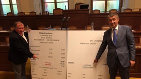 Vicepremiér Andrej Babiš (ANO) a poslanec ČSSD Vítězslav Jandák představují sněmovním kolegům velké makety účtenek pro elektronickou evidenci