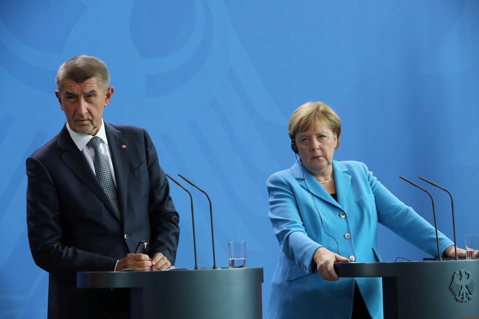 Andrej Babiš a Angela Merkelová se společně naklonili k novináři, který se ptal na aktuální dění v Chemnitzu (5. 9. 2018).