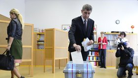 Andrej Babiš v černém, pro něj charakteristickém, obleku volí. Jeho paní odchází a pohled na ni potvrzuje rozpolcenost outfitu. K dané příležitosti diskutabilního stylingu.