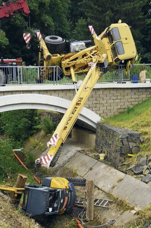 Autojeřáb zůstal viset na mostní konstrukci, bagr spadl do koryta řeky