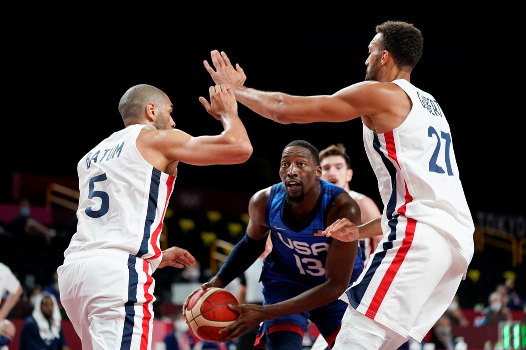 Američan Bam Adebayo se snaží prosmýknout mezi dvěma Francouzi