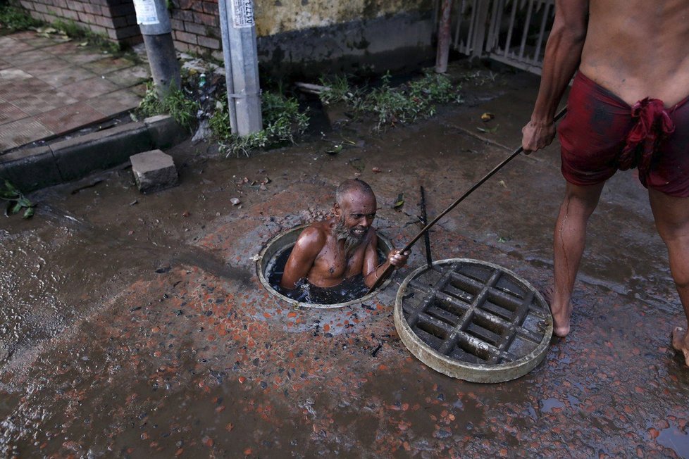 Hrůza a hnus. Čistič kanálů v Bangladéši při své práci.