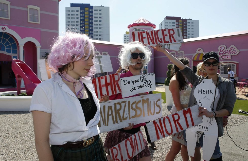 Aktivistky z feministické skupiny Femen doprovázené dalšími levicovými aktivisty před kopii domu pro barbíny v reálné velikosti