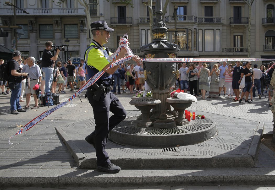 Policista odstraňuje pásku z náměstí Las Rampas v Barceloně, kde došlo ve čtvrtek v podvečer k útoku