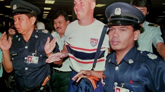 Singapurští policisté na letišti v Šanghaji v červenci 1999 deportují někdejšího zaměstnance zkrachovalé banky Barings Nicka Leesona do letadla mířícího do Londýna.
