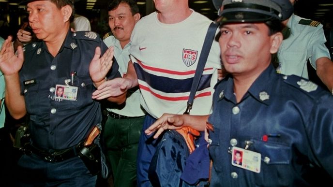 Singapurští policisté na letišti v Šanghaji v červenci 1999 deportují někdejšího zaměstnance zkrachovalé banky Barings Nicka Leesona do letadla mířícího do Londýna. Singapurští policisté na letišti v Šanghaji v červenci 1999 deportují někdejšího zaměstnance zkrachovalé banky Barings Nicka Leesona do letadla mířícího do Londýna.