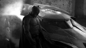 Ben Affleck jako Batman před svým Batmobilem.