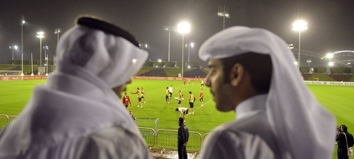 Dva fanoušci v tradičním arabském obleku sledují trénink Bayernu v Dauhá.