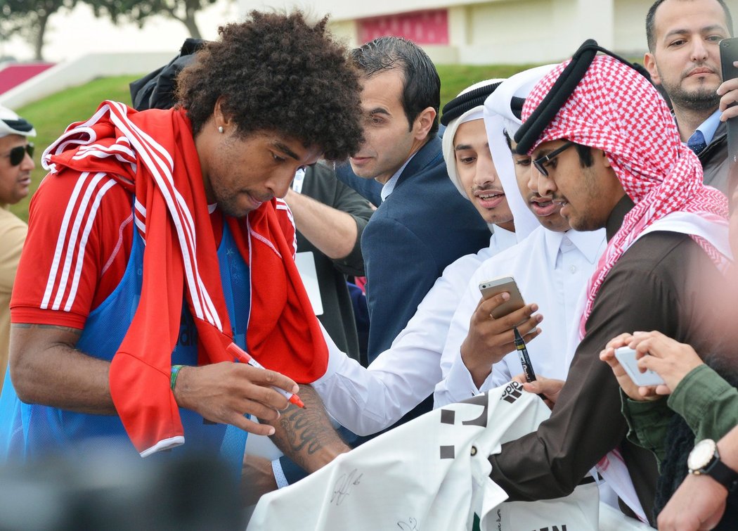 Stoper Dante se podepisuje fanouškům v Kataru, kteří navštívili trénink Bayernu.