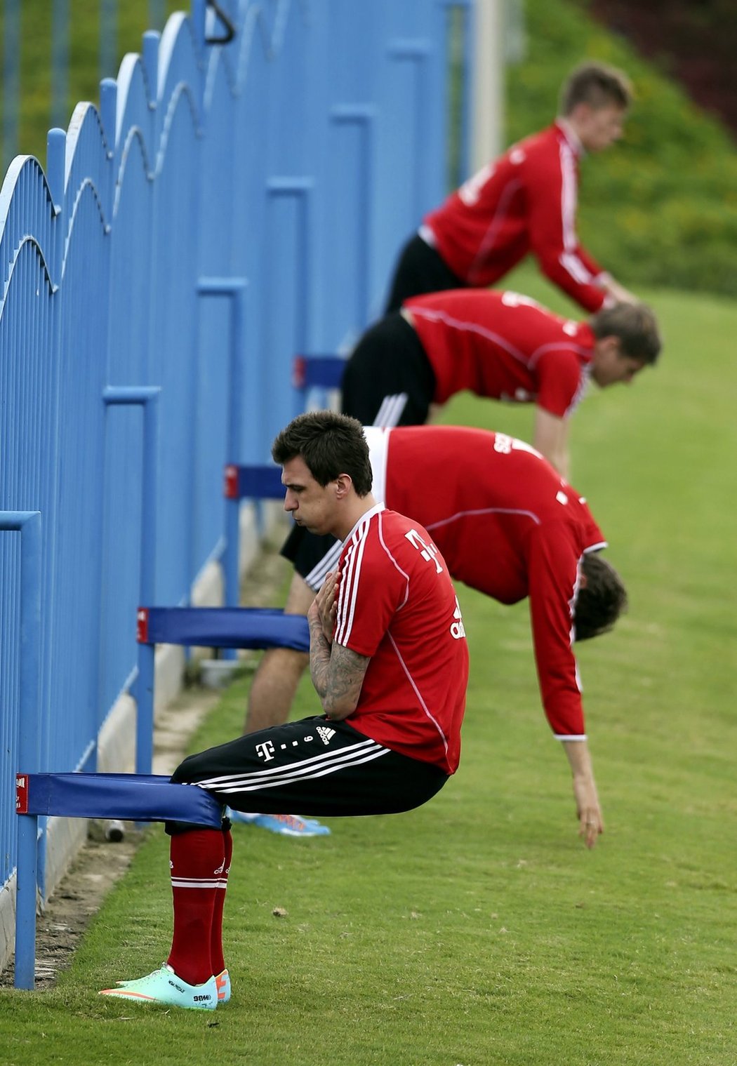 Fotbalisté Bayernu provádějí protahovací cvičení.