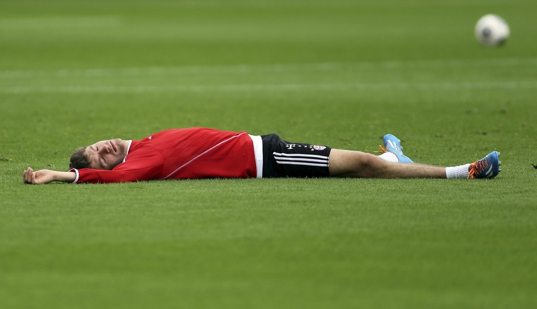 Zřejmě už bylo po tréninku. Thomas Müller leží na trávníku a odpočívá...