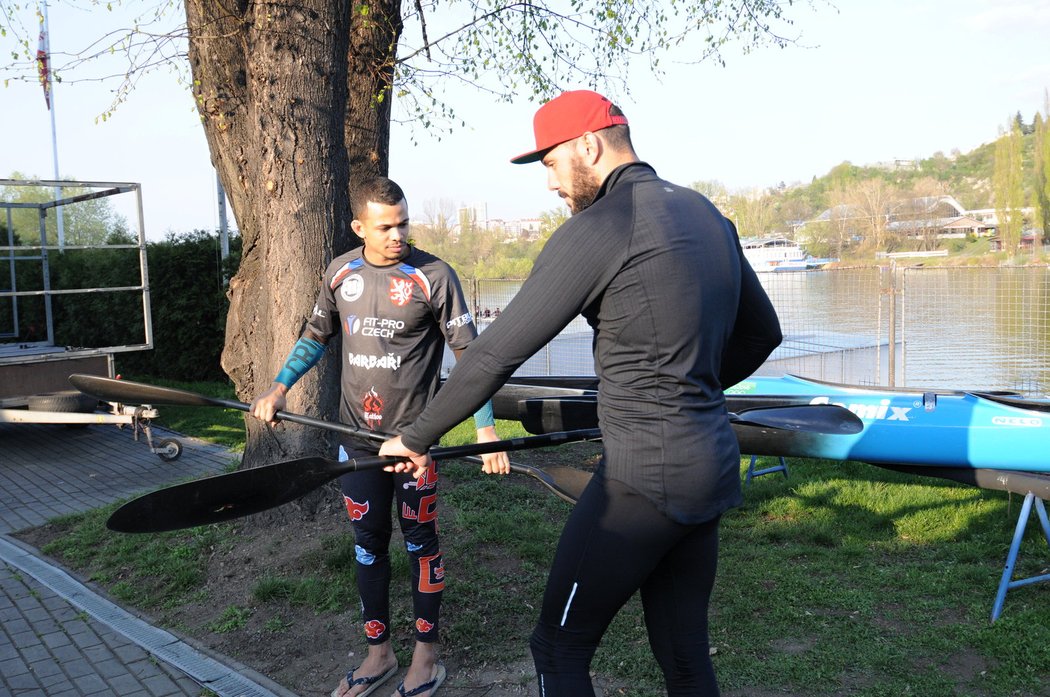 Josef Dostál na břehu Vltavy vysvětluje Benu Cristovao techniku pádlování