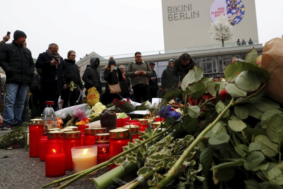 Lidé na místě neštěstí pokládají květiny a oplakávají oběti teroristického útoku.