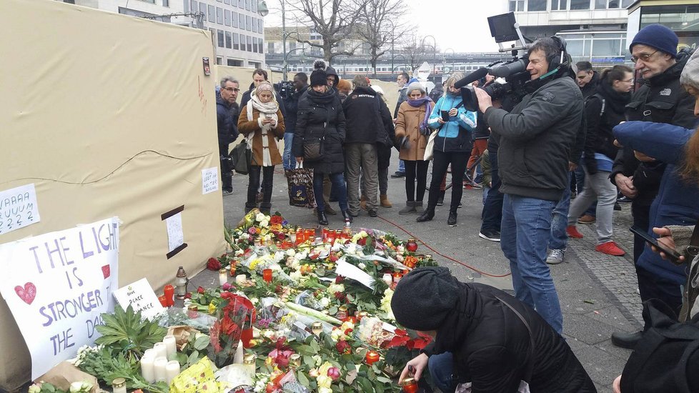 Masakr na vánočních trzích v Berlíně připomínají svíčky a policisté.