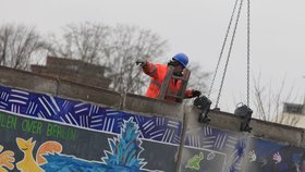 Stavbaři bourají Berlínskou zeď