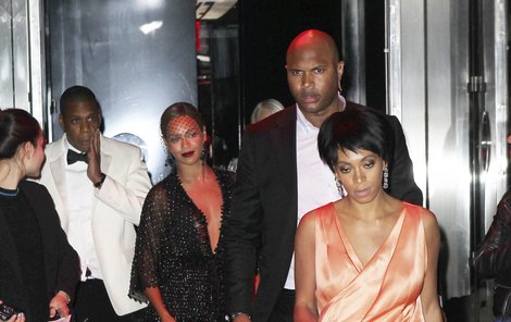 Solange jde z výtahu, za ní Beyoncé, Jay-Z si drží tvář.
