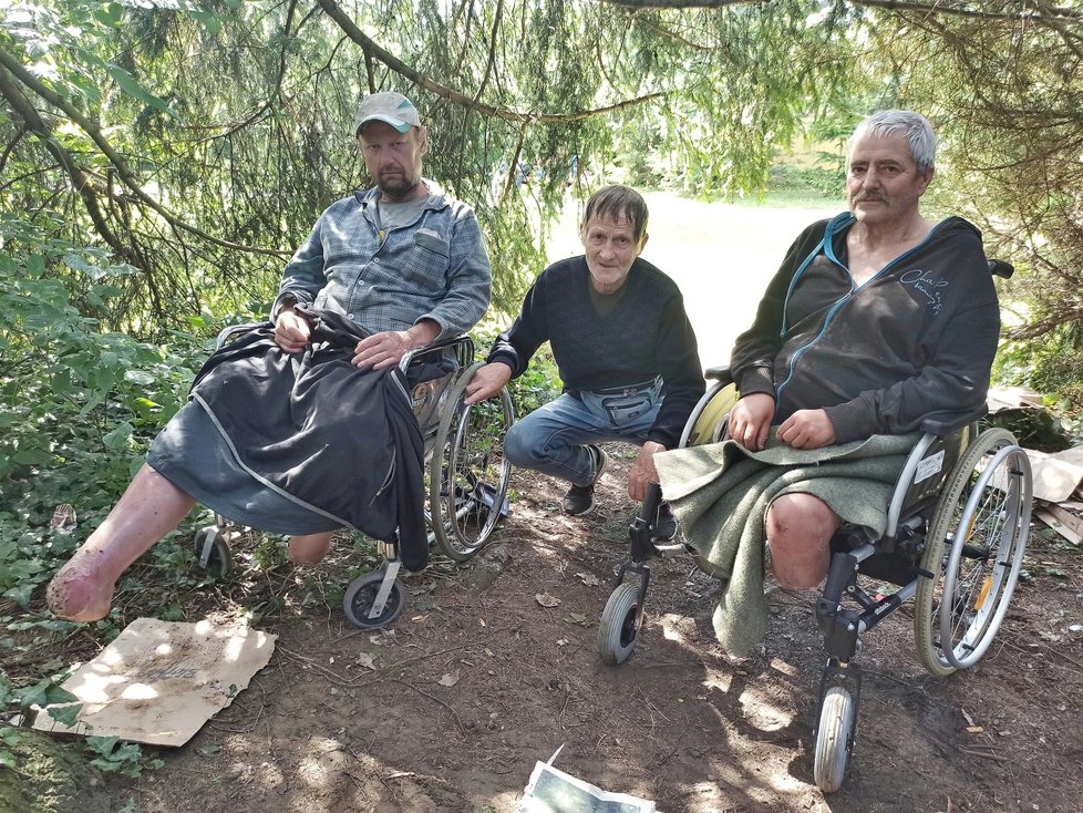 Bezdomovci s amputovanými nohami Petr a Libor (vpravo) táboří ve Frýdku-Místku pod košatým stromem. Jiří (uprostřed) jim občas pomáhá.