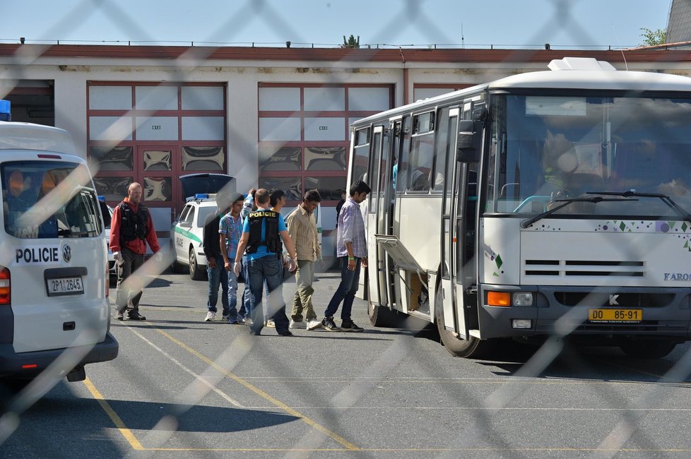 Zadržení běženci nastupují do autobusu