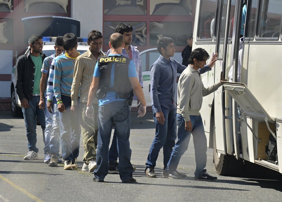 Zadržení běženci nastupují do autobusu