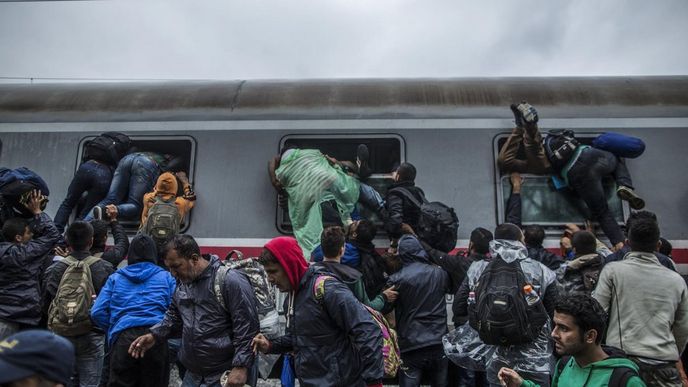 Běženci v chorvatském Tovarniku nastupují okny do vlaku, aby se vyhnuli policejnímu zátarasu