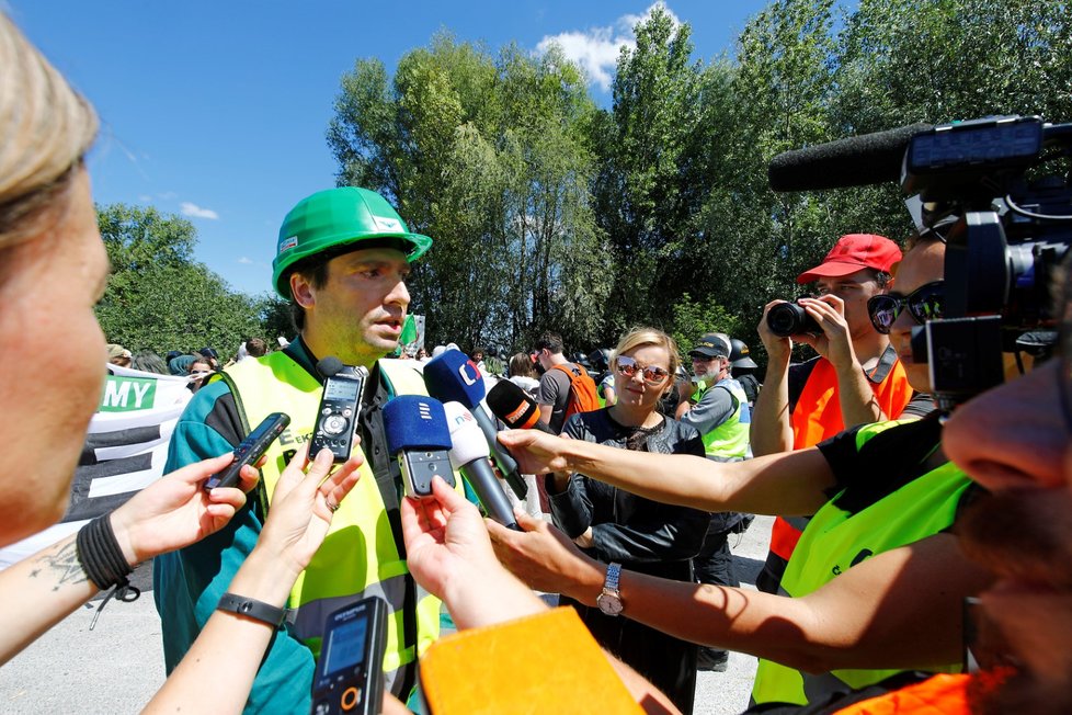 Mluvčí Severočeských dolů Lukáš Kopecký (vlevo) hovoří s novináři 30. června u dolu Bílina na Mostecku, kam zamířili aktivisté a demonstranti na protest proti těžbě uhlí.