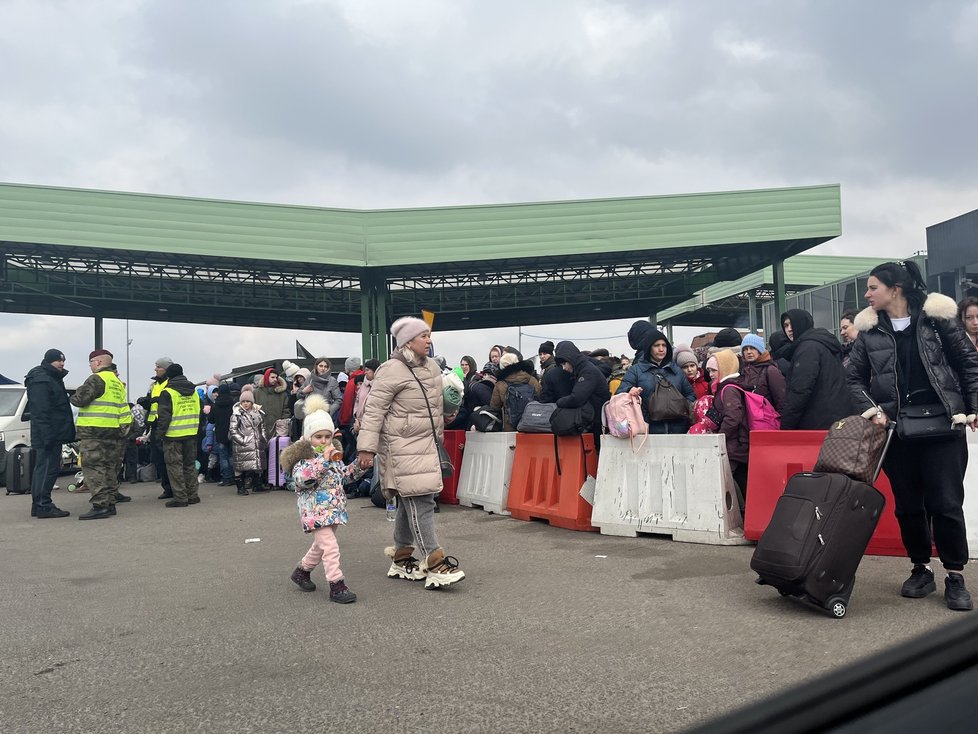 Davy lidí, převážně ženy a děti, proudí přes polsko-ukrajinskou hranici do bezpečí