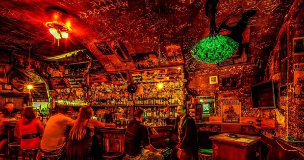 V baru jsou pokreslené zdi, červené světlo a schází se tam pražská smetánka.