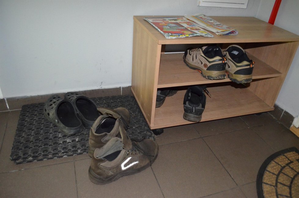 Dveře jeho bytu jsou zapečetěny, před ním jsou jen několikery boty.