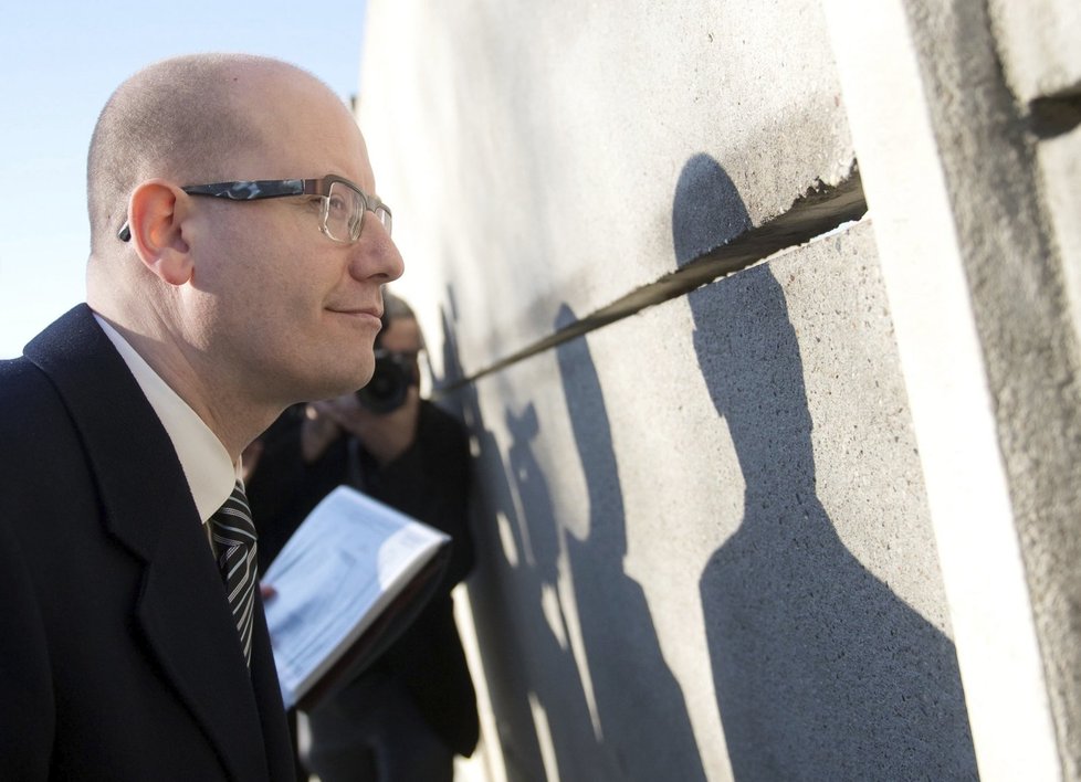 Bohuslav Sobotka zaujatě hledí skrz panely části Berlínské zdi. Překvapilo ho, že se tam střílelo ještě v roce 1989