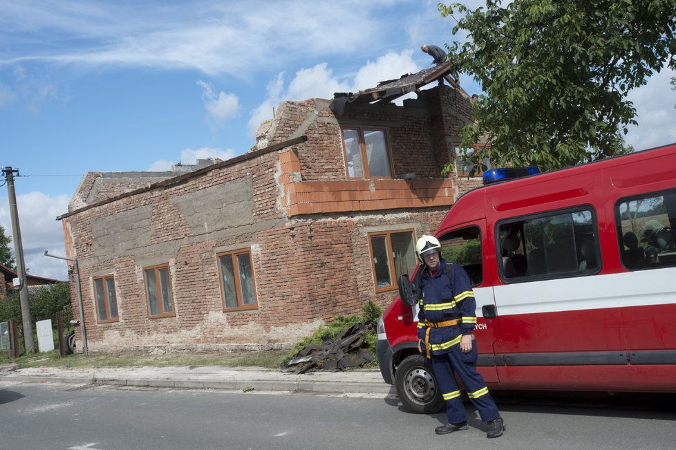 Zhruba osmdesát domů poškodila větrná smršť, která se v pátek 11. srpna kolem 17:30 prohnala Bohuslavicemi na Náchodsku. Nikdo nebyl zraněn, škody budou v milionech korun. Na snímku z 12. srpna hasiči pomáhají odstranit škody.