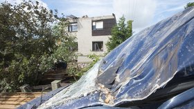 Zhruba osmdesát domů poškodila větrná smršť, která se v pátek 11. srpna kolem 17:30 prohnala Bohuslavicemi na Náchodsku. Nikdo nebyl zraněn, škody budou v milionech korun. Na snímku z 12. srpna vpředu je poškozené přední sklo vozidla, vzadu dům se zničenou střechou.