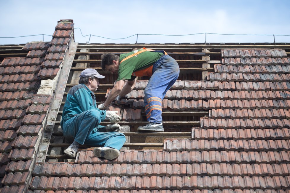 Zhruba osmdesát domů poškodila větrná smršť, která se v pátek 11. srpna kolem 17:30 prohnala Bohuslavicemi na Náchodsku. Nikdo nebyl zraněn, škody budou v milionech korun. Na snímku z 12. srpna obyvatelé obce odstraňují škody.