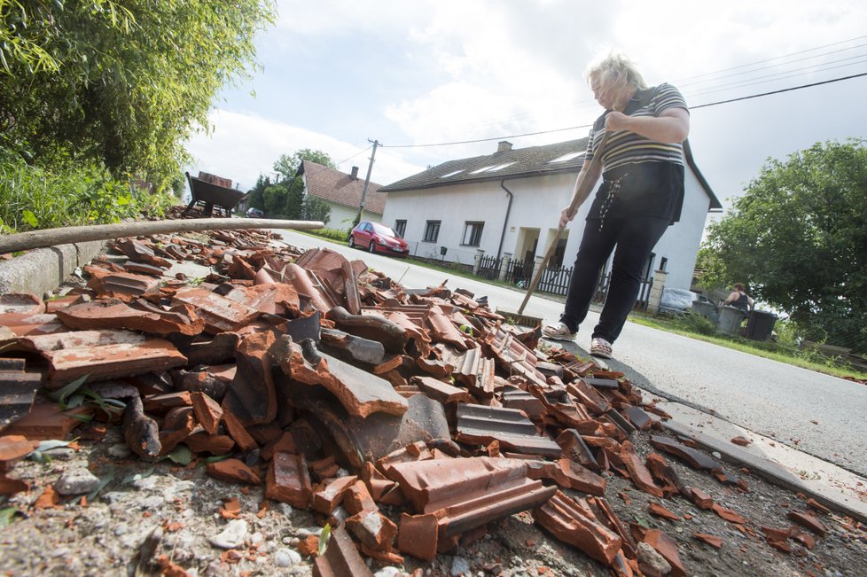 Zhruba osmdesát domů poškodila větrná smršť, která se v pátek 11. srpna kolem 17:30 prohnala Bohuslavicemi na Náchodsku. Nikdo nebyl zraněn, škody budou v milionech korun. Na snímku z 12. srpna obyvatelé obce odstraňují škody.