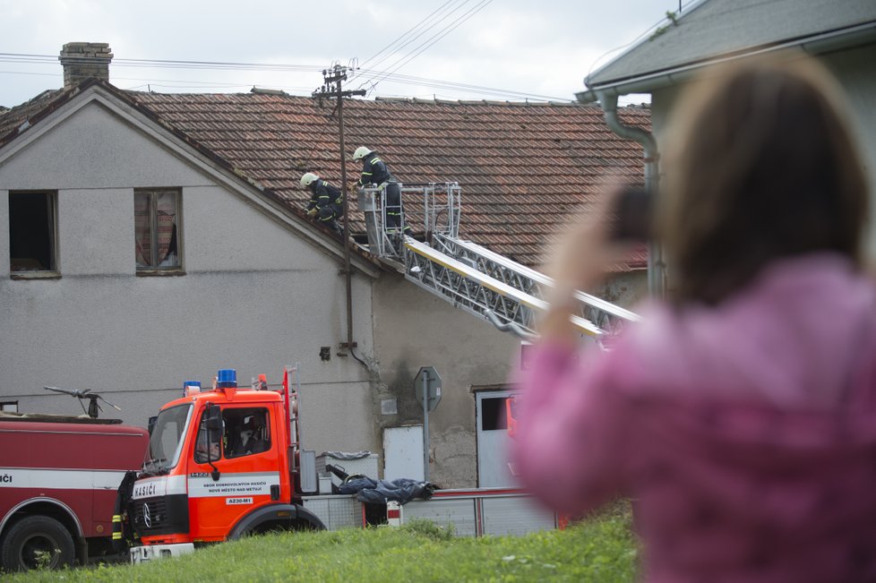 Zhruba osmdesát domů poškodila větrná smršť, která se v pátek 11. srpna kolem 17:30 prohnala Bohuslavicemi na Náchodsku. Nikdo nebyl zraněn, škody budou v milionech korun. Na snímku z 12. srpna hasiči pomáhají odstranit škody.