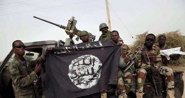 Vojáci drží vlajku Boko Haram z jejich obsazeného stanoviště (ilustrační foto)