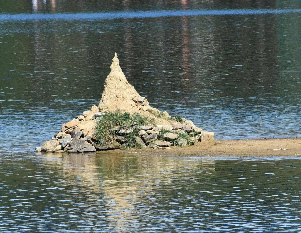 Hromádka z navršených kamenů na ostrově. V létě by mohla být už pod vodou a vidět by mohla být už jen špička.