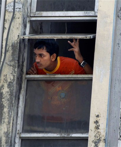 Kluk kouká z okna na chaos v ulicích Bombaje
