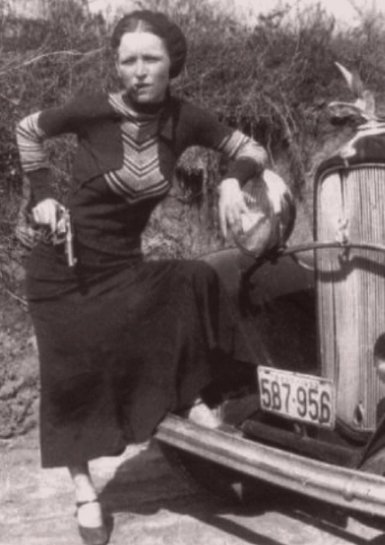 Bonnie Parker pózuje s doutníkem a zbraní.