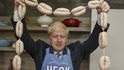 Boris Johnson drží během návštěvy v ústředí Heck Foods Ltd. řetěz uzenin (4. července 2019)