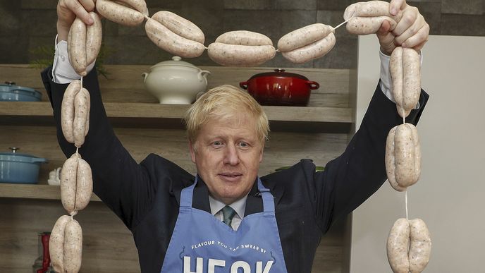 Boris Johnson, kandidát na vedení britské konzervativní strany, drží během návštěvy v ústředí Heck Foods Ltd. řetěz uzenin v rámci svého turné na vedoucího konzervativní strany poblíž Bedale v Británii 4. července 2019.