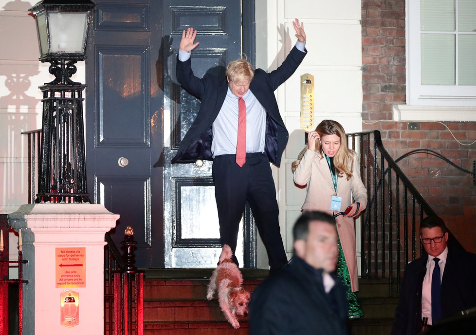 Boris Johnson a triumfální gesto po úspěšných volbách. S milenkou Carrie Symondsovou a jejich psem vyrazil oslavit porážku labouristů. (13.12.2019)
