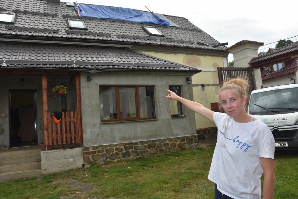 Olga Sporadová (21) ukazuje na poničený dům, ve kterém přečkala downburst.